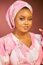 Elegant portrait of a woman wearing pink traditional clothing and headscarf.